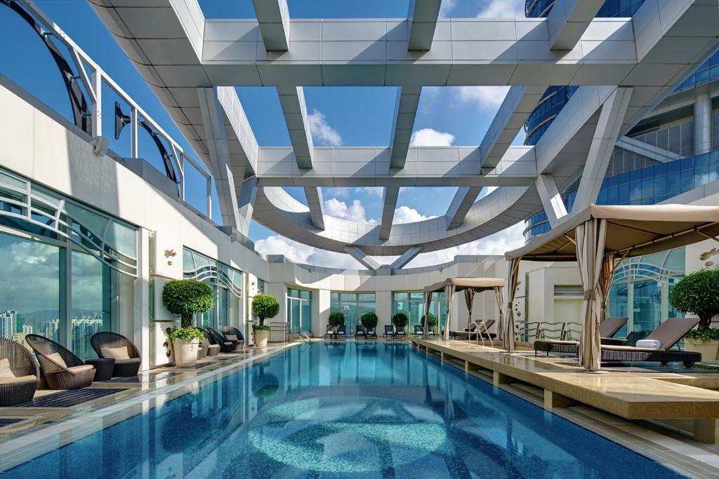香港にあるコルディス ホンコンの天井の高い建物内の屋内プール
