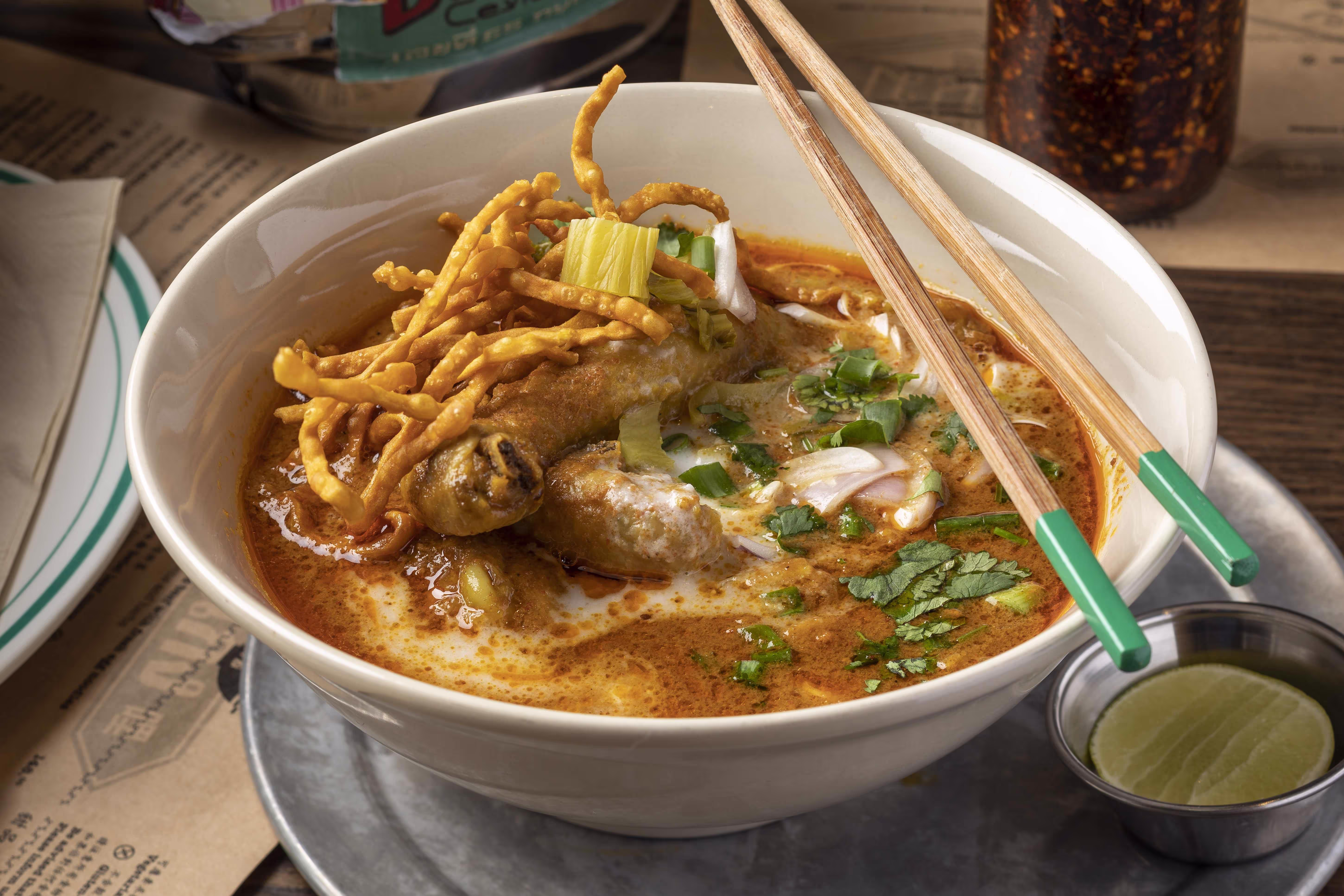 "Khao Soi" of curried chicken with fresh egg noodles, pickled mustard greens and herbs
